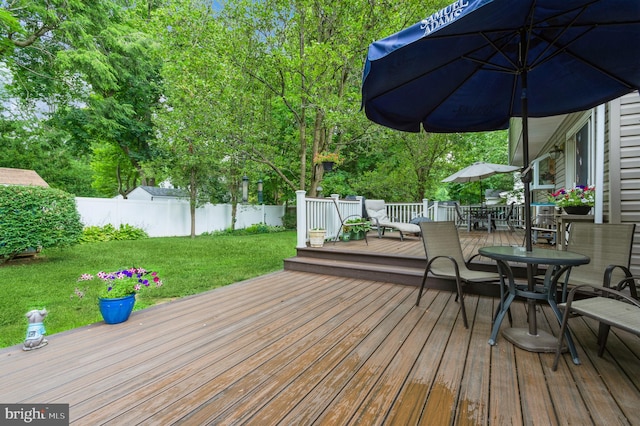 wooden terrace featuring a lawn