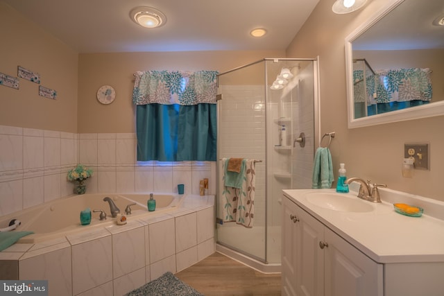 bathroom with plus walk in shower, vanity, and hardwood / wood-style flooring