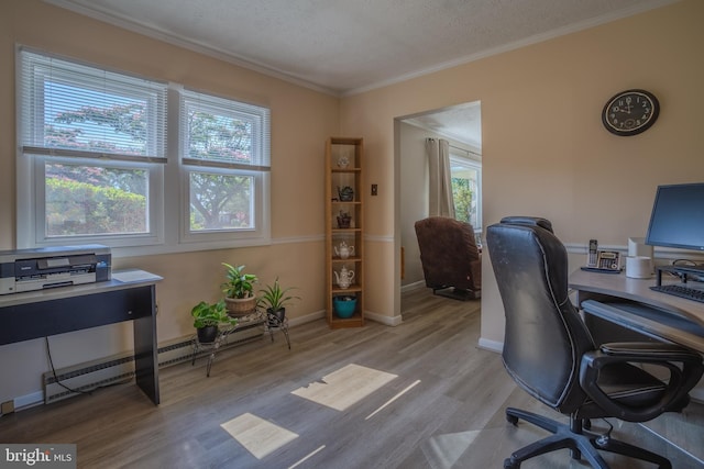 home office featuring a healthy amount of sunlight, light wood-type flooring, a textured ceiling, and a baseboard heating unit