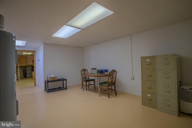 interior space with a paneled ceiling and water heater