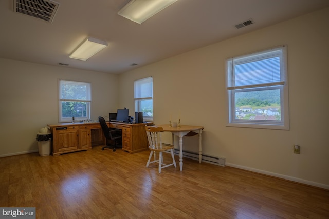 office space with light wood-type flooring and a baseboard heating unit