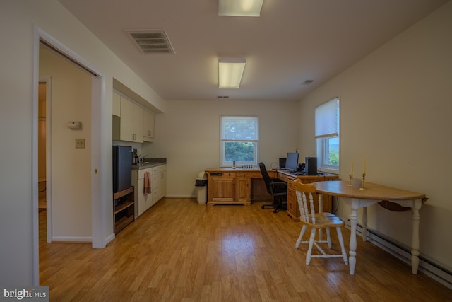 kitchen with baseboard heating, white cabinetry, and light wood-type flooring