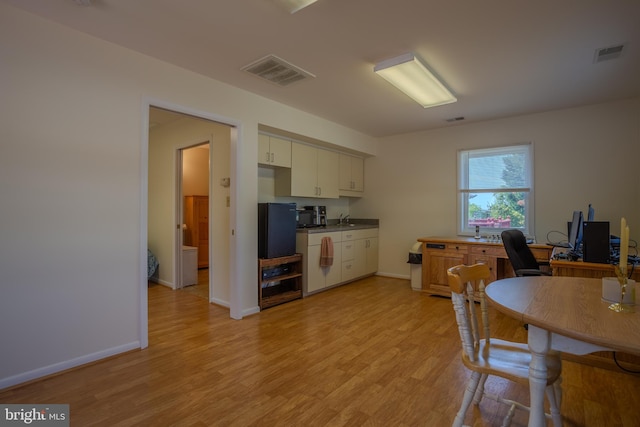 kitchen featuring white cabinets, sink, and light hardwood / wood-style flooring