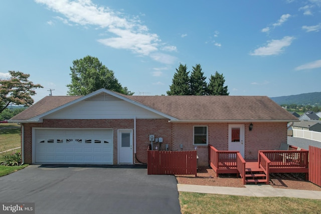 single story home featuring a garage and a wooden deck