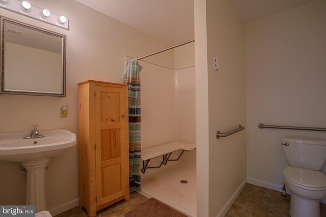 bathroom featuring a shower with curtain, sink, and toilet