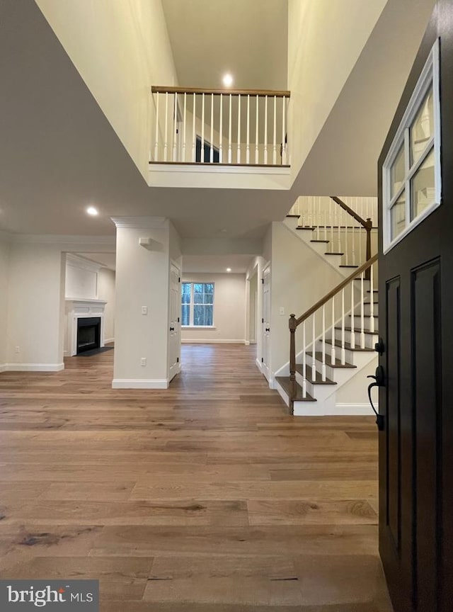 kitchen featuring dark hardwood / wood-style floors, white cabinets, wall chimney range hood, and stainless steel appliances