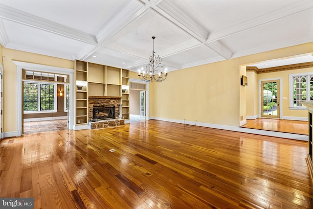 unfurnished living room featuring beam ceiling, an inviting chandelier, and coffered ceiling