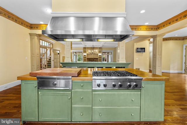 kitchen featuring a kitchen island, green cabinetry, ornamental molding, and exhaust hood