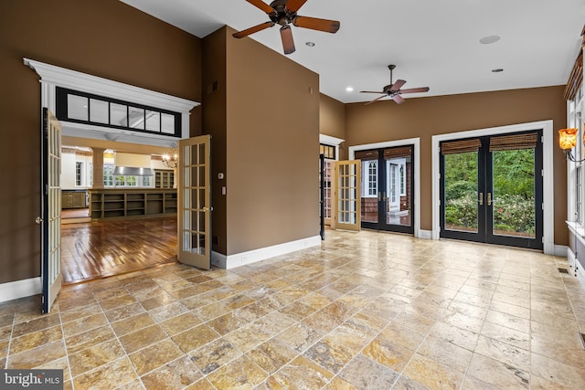 empty room featuring ceiling fan, french doors, and vaulted ceiling