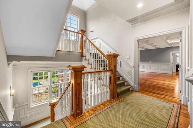 staircase featuring beam ceiling, hardwood / wood-style flooring, crown molding, and coffered ceiling