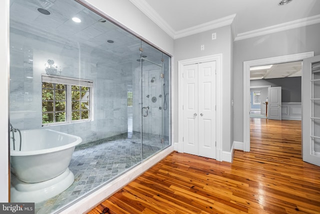 bathroom featuring crown molding, plus walk in shower, and wood-type flooring