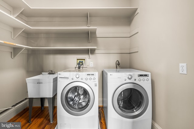 washroom featuring washing machine and dryer, dark hardwood / wood-style flooring, and sink