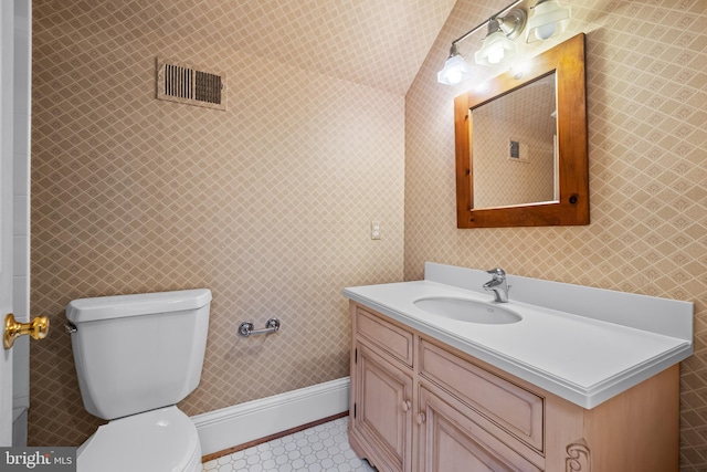 bathroom with vanity, vaulted ceiling, and toilet