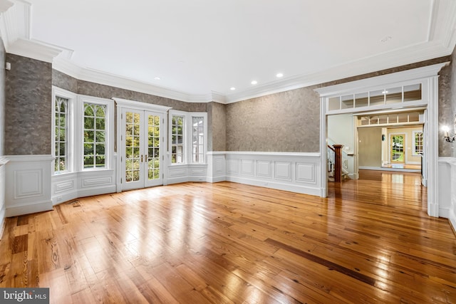 spare room featuring french doors, light hardwood / wood-style floors, and crown molding