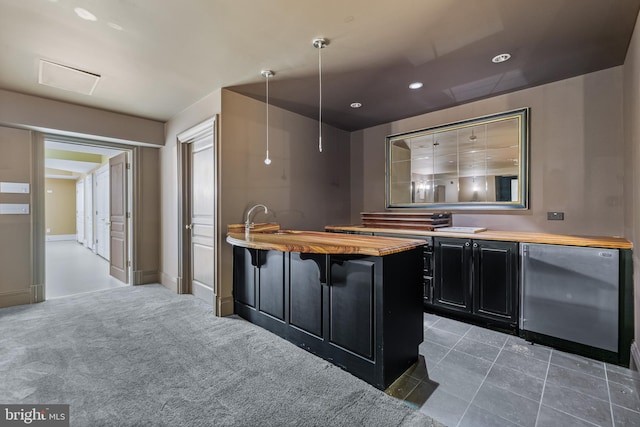 kitchen with pendant lighting, a breakfast bar, dark carpet, fridge, and butcher block counters