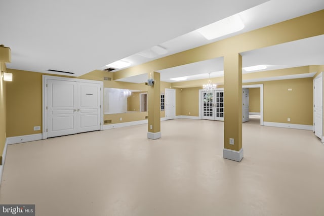 basement with a notable chandelier and french doors