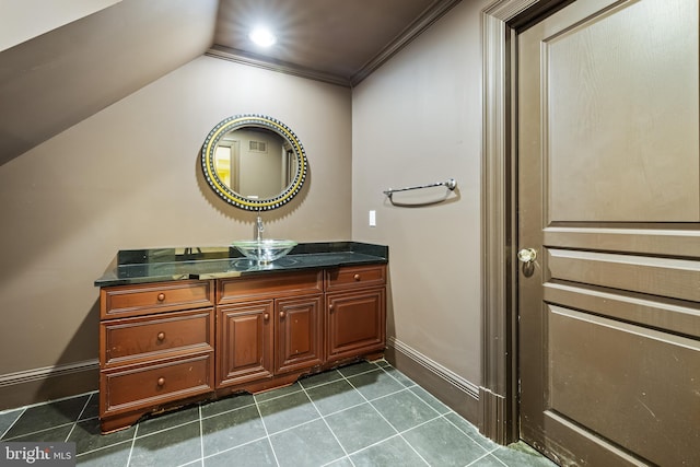 bathroom with tile patterned floors, lofted ceiling, ornamental molding, and vanity