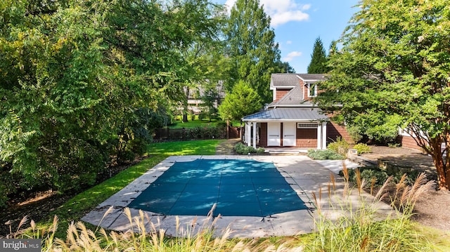 view of swimming pool featuring a lawn and a patio