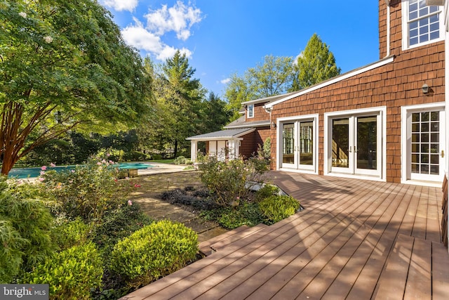 deck with french doors and a swimming pool