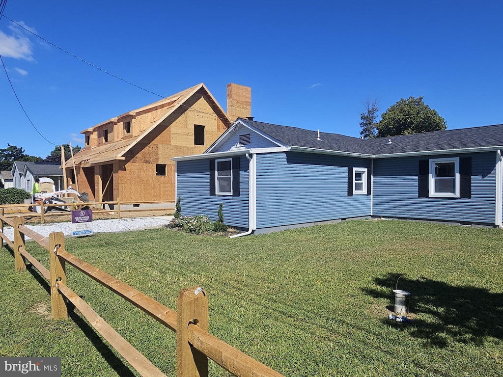 rear view of house featuring a yard