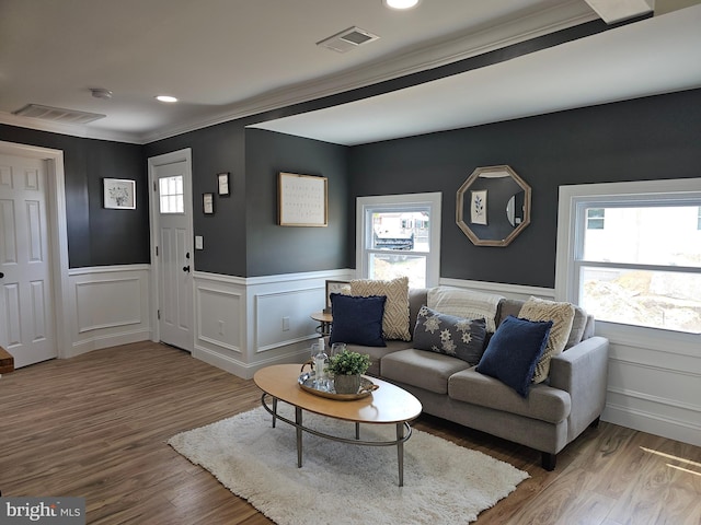 living room with wood-type flooring and crown molding