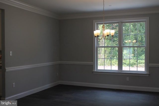 spare room featuring ornamental molding, dark hardwood / wood-style floors, and an inviting chandelier