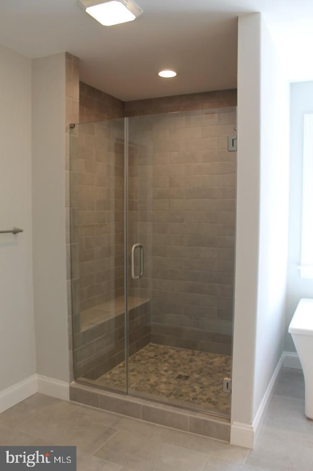 bathroom featuring tile patterned flooring and a shower with shower door