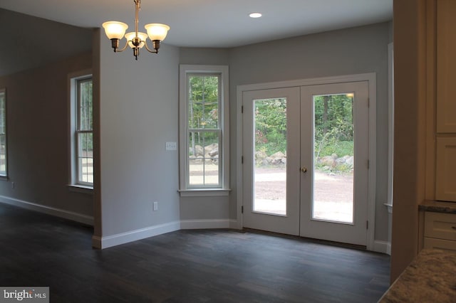 doorway with french doors, a healthy amount of sunlight, and an inviting chandelier