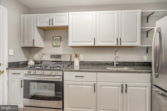 kitchen featuring sink, white cabinets, dark stone counters, and stainless steel appliances