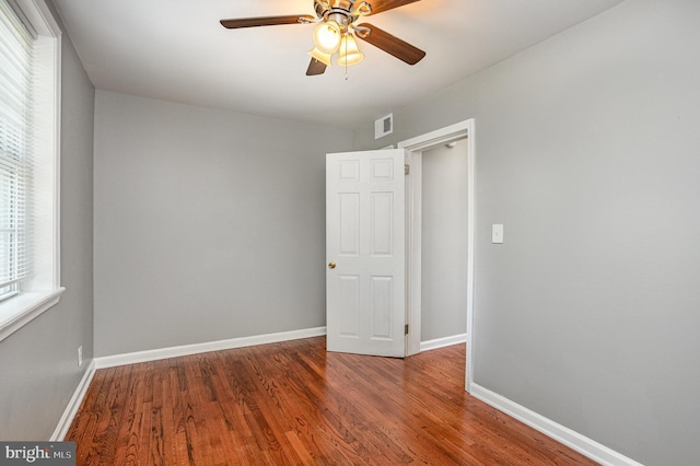 empty room with hardwood / wood-style flooring and ceiling fan