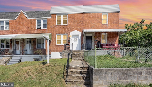 view of front of property with a porch and a yard