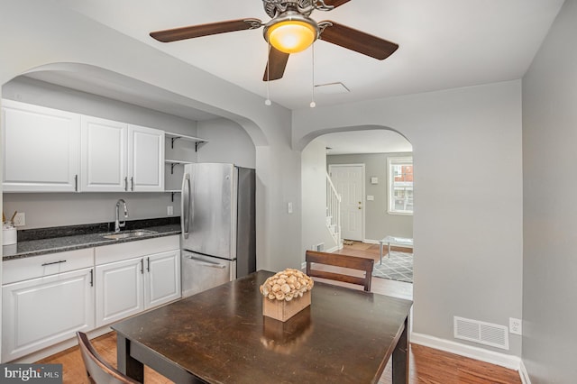 dining area featuring sink, hardwood / wood-style flooring, and ceiling fan