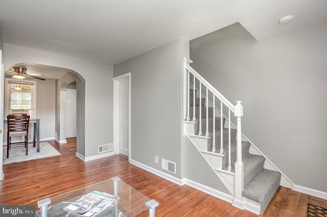 stairs with ceiling fan and hardwood / wood-style floors