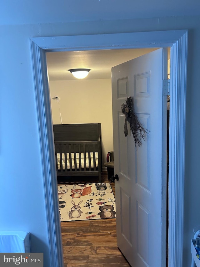 interior space with a crib and dark hardwood / wood-style flooring