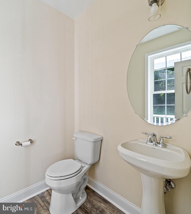 bathroom featuring wood-type flooring and toilet