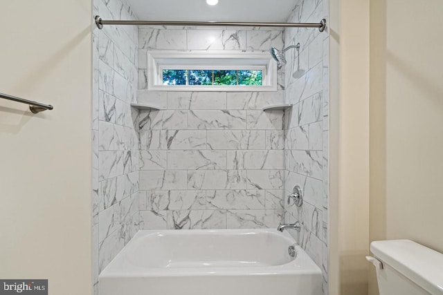 bathroom featuring toilet and tiled shower / bath