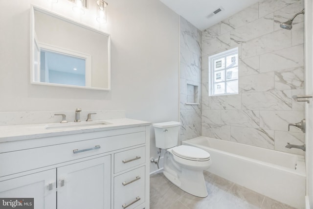 full bathroom with toilet, vanity, and tiled shower / bath