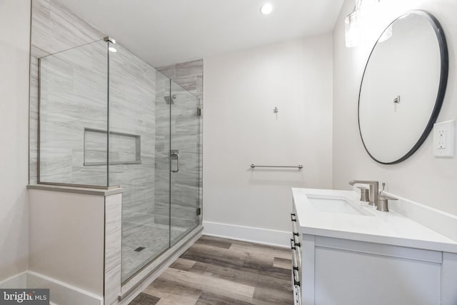 bathroom with vanity, wood-type flooring, and a shower with door