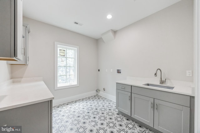 clothes washing area featuring cabinets, hookup for a washing machine, electric dryer hookup, sink, and hookup for a gas dryer