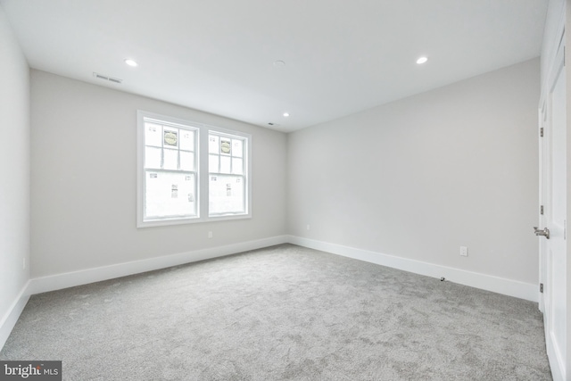 unfurnished room featuring light carpet