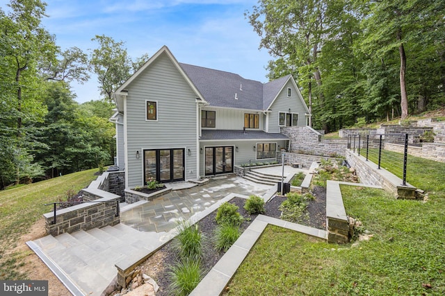 rear view of property featuring a lawn and a patio