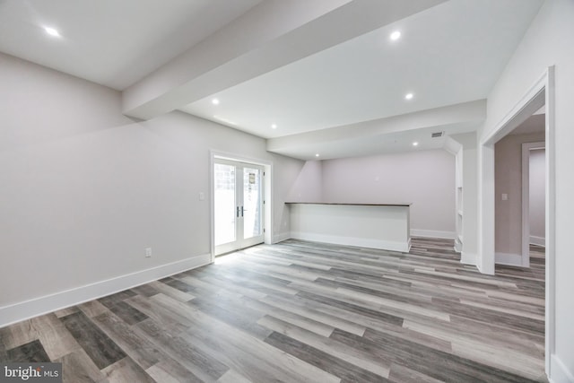 unfurnished living room with light hardwood / wood-style floors and french doors