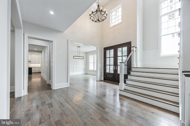 entrance foyer featuring french doors, dark hardwood / wood-style floors, and a notable chandelier