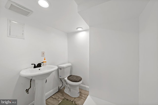 bathroom with hardwood / wood-style flooring, sink, and toilet