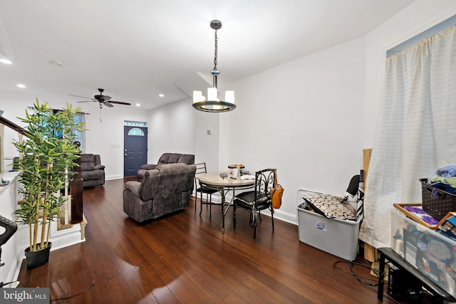 interior space featuring ceiling fan with notable chandelier and dark wood-type flooring