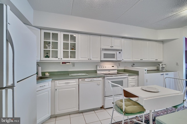 kitchen featuring light tile patterned flooring, white cabinetry, a textured ceiling, and white appliances