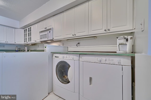 washroom with washing machine and clothes dryer and light tile patterned flooring