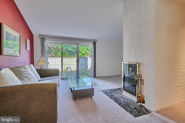 living room with carpet floors, brick wall, a brick fireplace, and vaulted ceiling