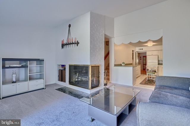 carpeted living room featuring brick wall and a multi sided fireplace