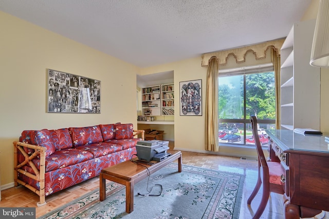 living room with a textured ceiling and parquet flooring